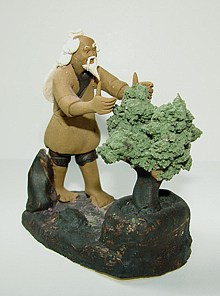 Oriental figurine of man trimming a bonsai tree, small fountain decoration